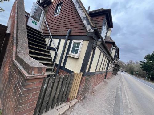 a house with a fence on the side of a street at The Shoe Inn Rooms in Southampton
