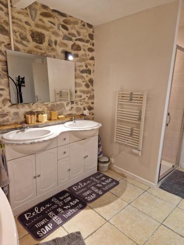 une salle de bain avec un lavabo et un miroir dans l'établissement Petite maison au cœur du village, à Cessenon