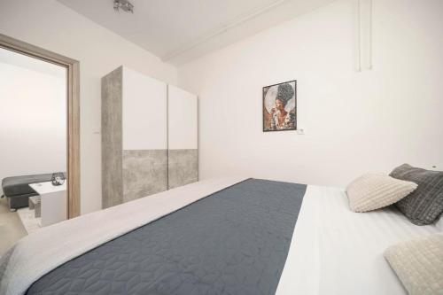 a white bedroom with a large bed in it at Carpe Diem in Raslina