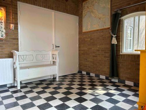 Habitación con puerta blanca y suelo a cuadros en Sfeervol Overnachten in de Kerk, en Amersfoort