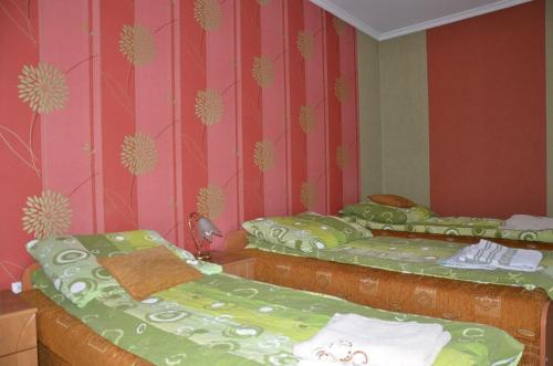 two twin beds in a room with pink walls at Zajazd U Renaty in Poraj