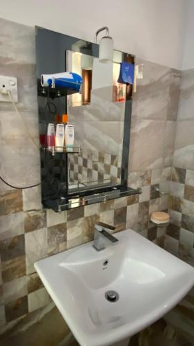a bathroom with a white sink and a mirror at Jayamal Piyasa Apt in Ambalangoda