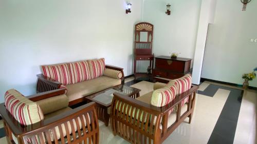 a living room with a couch and chairs and a table at Jayamal Piyasa Apt in Ambalangoda