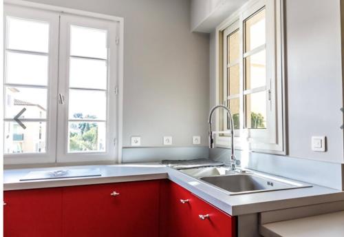 une cuisine avec un évier et deux fenêtres dans l'établissement My little Paradise in ST-TROPEZ, à Saint-Tropez