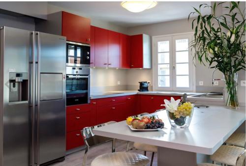 - une cuisine avec des placards rouges et une table avec un bol de fruits dans l'établissement My little Paradise in ST-TROPEZ, à Saint-Tropez