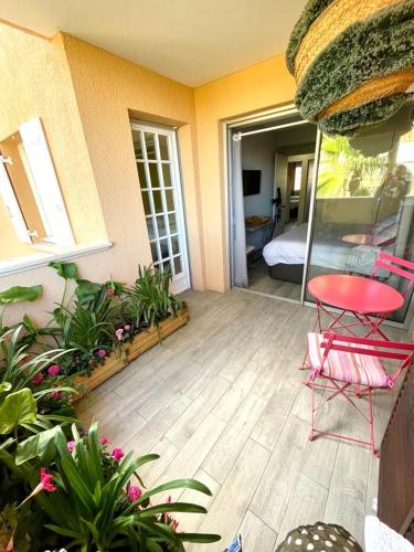 un patio avec une table et des chaises rouges et une chambre dans l'établissement My little Paradise in ST-TROPEZ, à Saint-Tropez