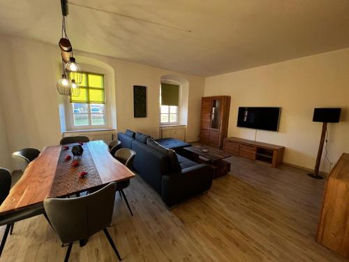 a living room with a wooden table and a couch at Gut Rottmannshagen Mecklenburgische Seenplatte in Jürgenstorf