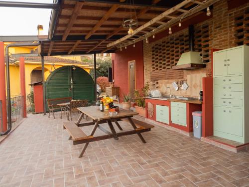a patio with a wooden table and a kitchen at Villa Il Rustichino, country Villa with Pool in Soianella