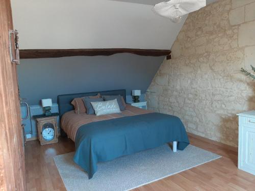 a bedroom with a bed with a blue comforter at Au pied du Lavoir Chambre Odile in Grézillé