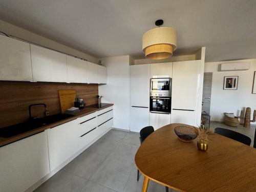 une cuisine avec une table en bois et une salle à manger dans l'établissement Bel appartement T3 vue mer 5 min des plages à pied, à Propriano