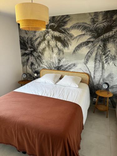 - une chambre avec un lit orné d'une fresque murale en palmier dans l'établissement Bel appartement T3 vue mer 5 min des plages à pied, à Propriano