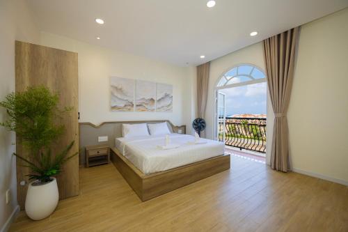 a bedroom with a large bed and a balcony at Lotus Home Cafe - Cable Car Station in Phú Quốc