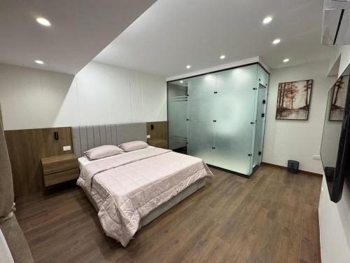 a bedroom with a large bed and a glass closet at جناح فندقي بغرفتي نوم 5 نجوم في المهندسين 10a Deluxe Suite in Cairo