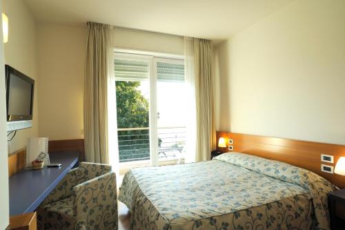 ein Hotelzimmer mit einem Bett und einem Fenster in der Unterkunft Hotel Le Roi in Varraze