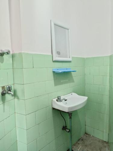 a bathroom with a sink and a mirror on the wall at Hotel Sakura Mountain view Near Darjeeling Toy Train Station in Darjeeling