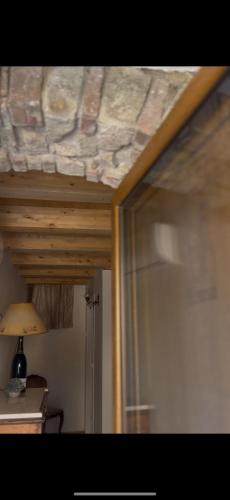 a bedroom with a wooden ceiling and a glass door at B&B Alle Carceri dei Filangieri in Lapio