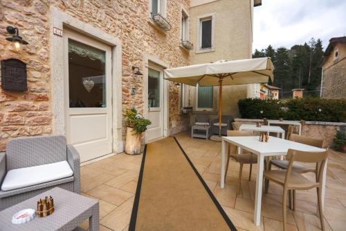 a patio with a table and chairs and an umbrella at Casa Leon d'Oro in Bosco Chiesanuova