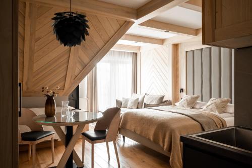 a bedroom with a bed and a table in a room at Villa Las Apartamenty in Zakopane