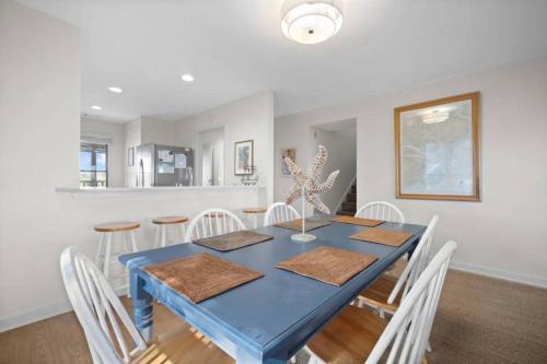 une salle à manger avec une table bleue et des chaises blanches dans l'établissement Cozy Doref Villa, à Saint-Tropez