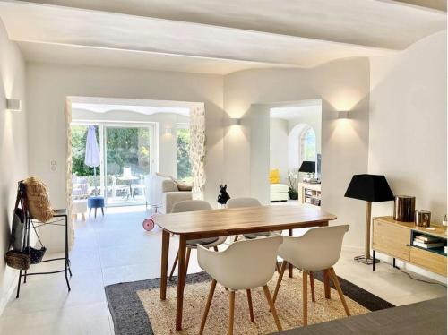 une salle à manger avec une table en bois et des chaises blanches dans l'établissement Lovely 2 bedroom garden apartment in Cannes, à Cannes
