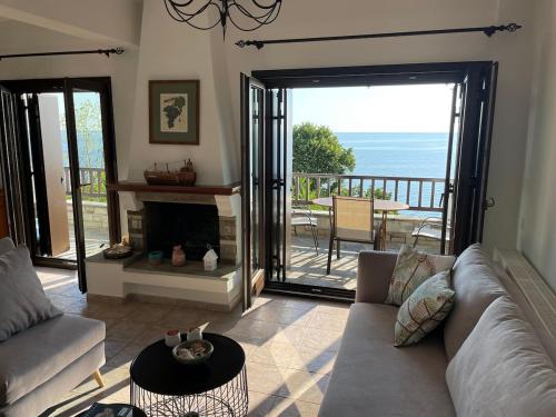 a living room with a couch and a fireplace at Just renovated seaside home 80 meters from the sea in Agios Ioannis Pelio