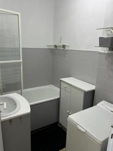 a white bathroom with a sink and a toilet at Petite escapade à la Picardière in Fort-Mahon-Plage