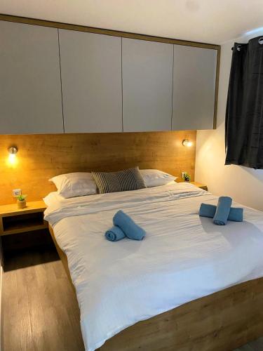 a large white bed with two blue pillows on it at Mobilna kućica Neda - Grebaštica, kamp Vala in Grebaštica