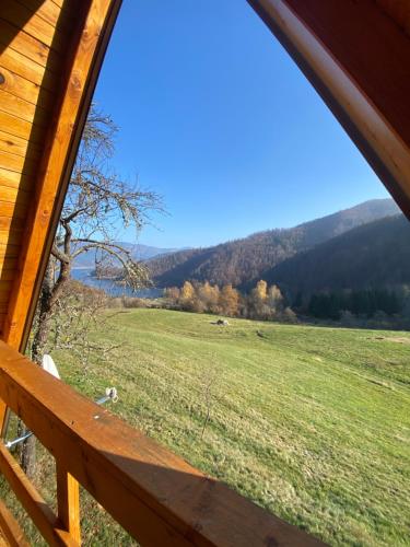 a view of a field from a cabin window at Brvnara Iva in Jezdići