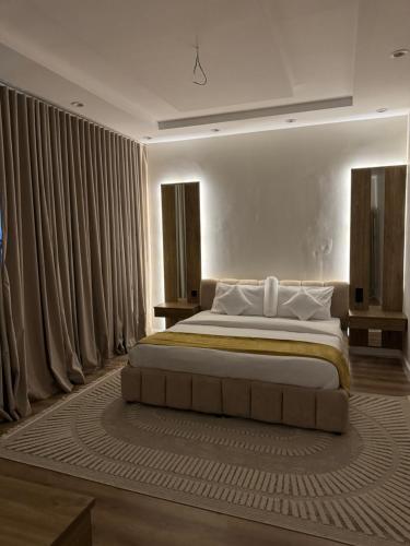 a bedroom with a large bed with curtains at Suits studio in AlUla