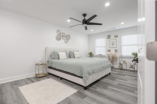 a white bedroom with a bed and a ceiling fan at Big Modern Family Home On 1 Acre Land w Firepit & Grill in Ellenwood