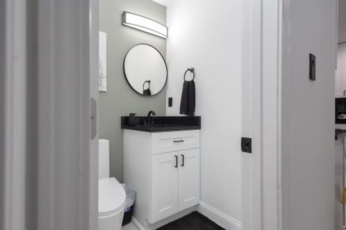 a white bathroom with a toilet and a mirror at Big Modern Family Home On 1 Acre Land w Firepit & Grill in Ellenwood