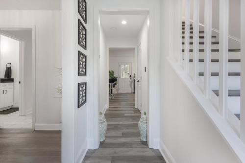 a hallway with white walls and a white staircase at Big Modern Family Home On 1 Acre Land w Firepit & Grill in Ellenwood