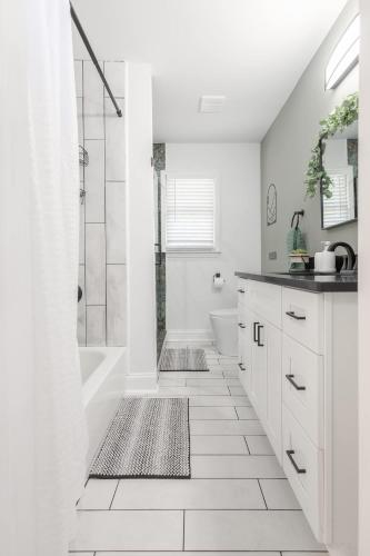 a white bathroom with a shower and a sink at Big Modern Family Home On 1 Acre Land w Firepit & Grill in Ellenwood