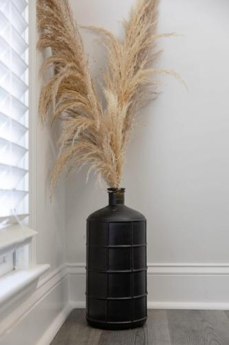a black vase with feathers in a room at Big Modern Family Home On 1 Acre Land w Firepit & Grill in Ellenwood