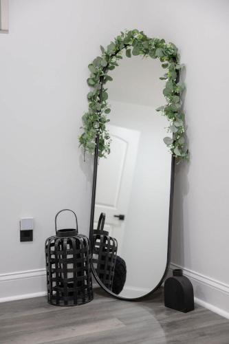 a mirror with a plant on it next to a suitcase at Big Modern Family Home On 1 Acre Land w Firepit & Grill in Ellenwood