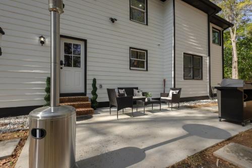 a porch of a house with chairs and a grill at Big Modern Family Home On 1 Acre Land w Firepit & Grill in Ellenwood