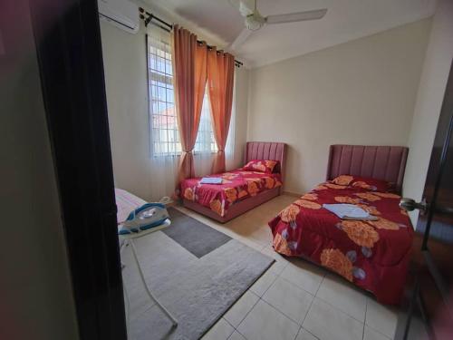a bedroom with two beds and a window at Rossa Homestay, Kok Lanas in Kampong Kok Lanas