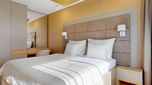 a hotel room with a large bed with white pillows at Eurovea Tower Apartments in Petržalka