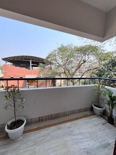 a balcony with two potted plants on it at Expressway Minimalist Beltola - Hostel in Guwahati