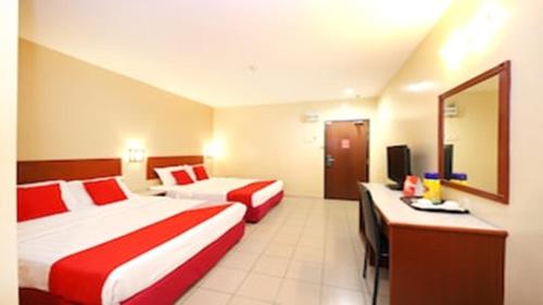 a hotel room with two beds and a mirror at Super OYO 447 Comfort Hotel Meru in Klang