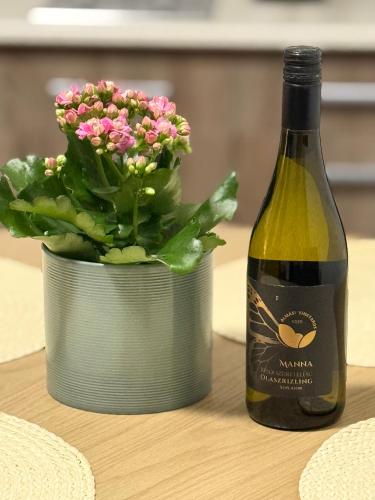 エゲルサロークにあるFerzs Apartman Egerszalókの鉢植えの隣のワイン1本