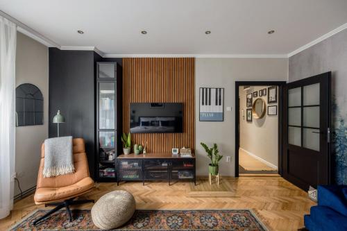 a living room with a chair and a television at Oázis Apartman in Veszprém