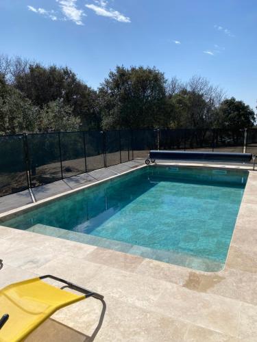 - une piscine avec une chaise jaune à côté dans l'établissement Maison de campagne avec piscine à Bédoin, Mont Ventoux, à Bédoin