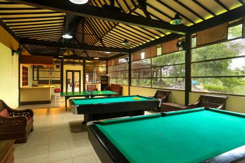 a billiard room with four pool tables in it at Plengkung Lodge G-Land in Ringinpintu