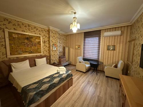a bedroom with a bed and a desk and chairs at Safir Hotels Silivri in Silivri