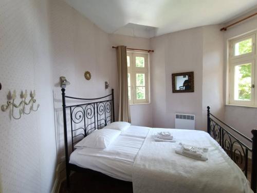 a bedroom with a large bed with white sheets at Château de Vallagon in Montrichard