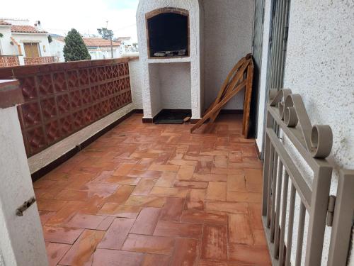 balcón con suelo de madera y TV en Maison dans Résidence piscine, en Roses