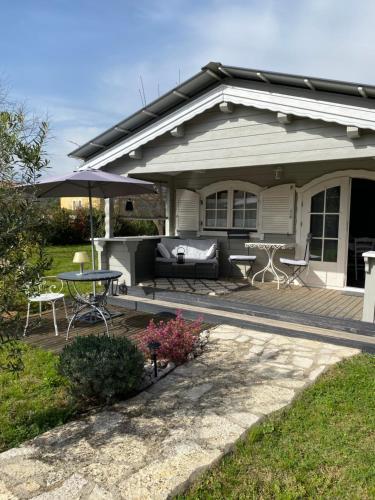 a house with a patio with a table and an umbrella at Chalet de Charme in Aniane