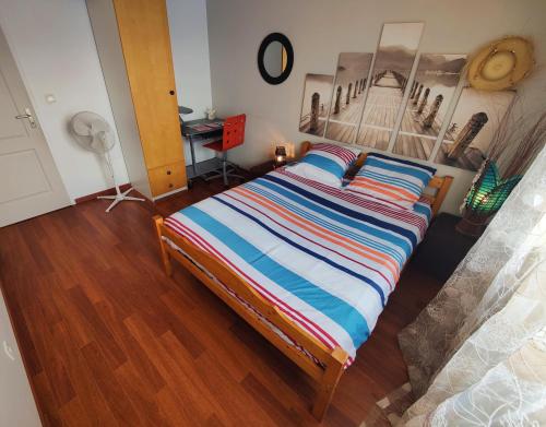a bedroom with a bed with a striped comforter at La Suite Soleil in Gujan-Mestras
