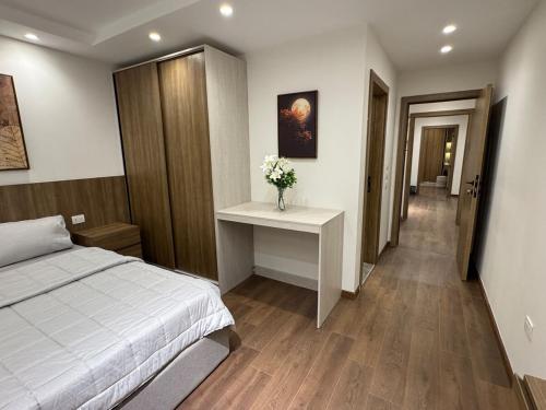 a bedroom with a bed and a table with flowers on it at جناح فندقي بغرفتي نوم 5 نجوم في المهندسين 10b Deluxe Suite in Cairo